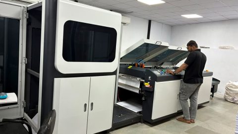 Skilled Press Operator Performing Quality Control During Printing